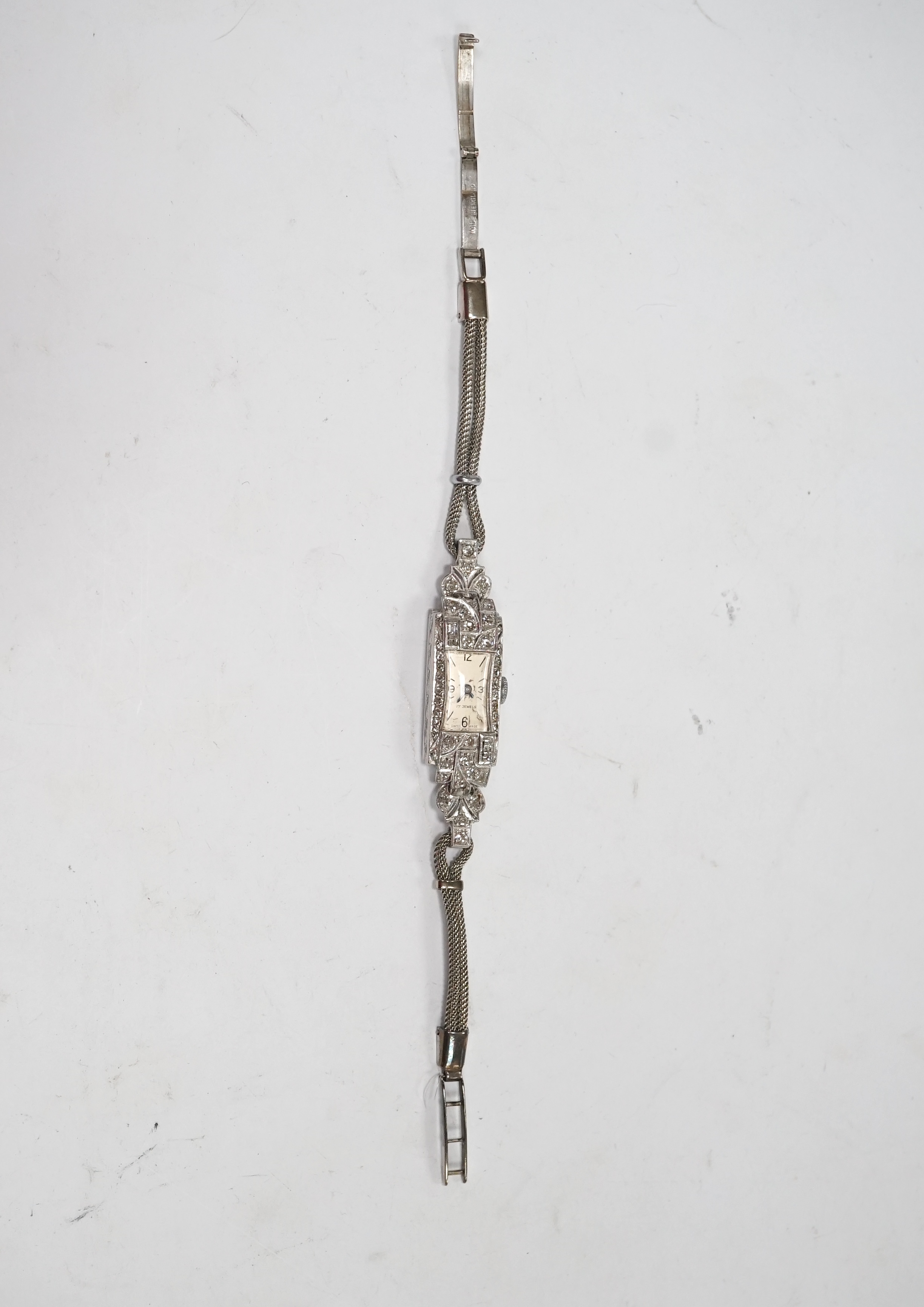 A lady's mid 20th century white metal (stamped platinum) and diamond set manual wind cocktail watch, on a 9ct white metal twin strand bracelet, overall length 16.5cm, gross weight 17.6 grams/ Condition - fair to good